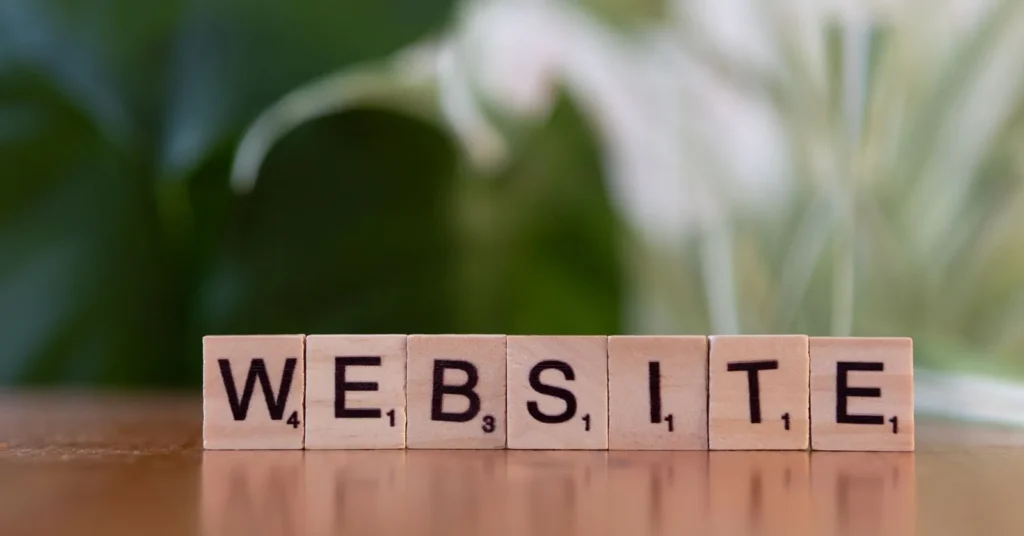 Scrabble tiles on a wooden surface forming the word 'Website', symbolizing digital communication